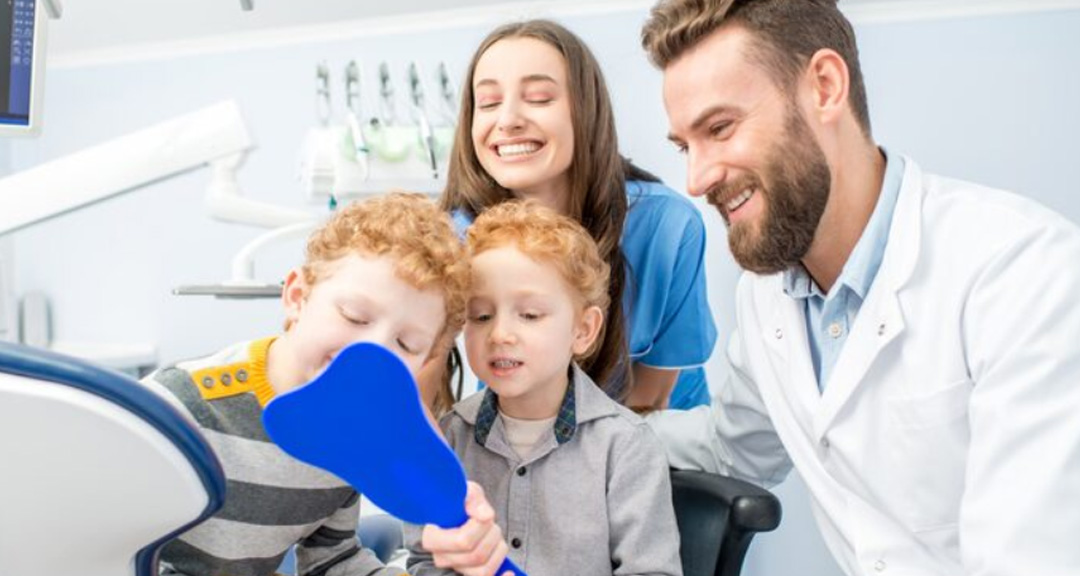 Two young children with their mum and dentist at a family dentist Ormeau check-up